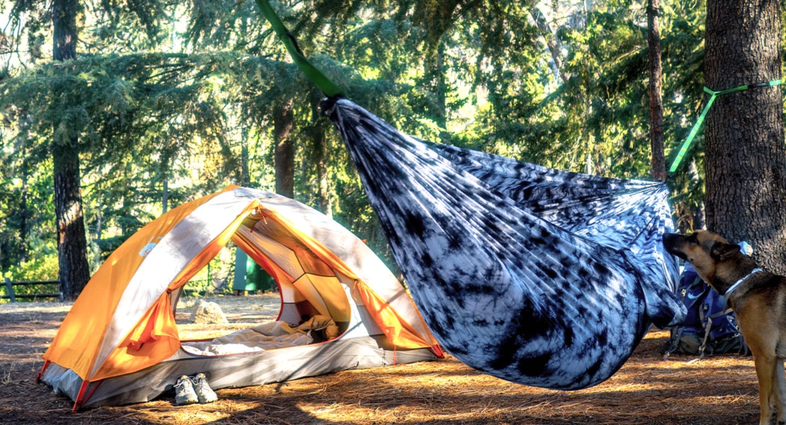 Grand Trunk Goods hammock near an open tent during the day at a campground