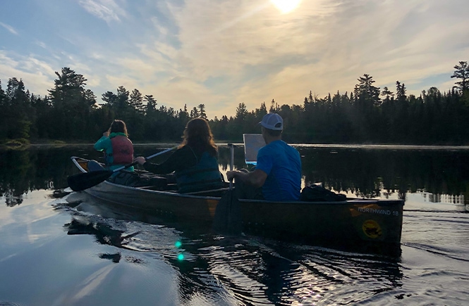 Reading a map from the canoe at Boundary Waters Canoe Area Wilderness